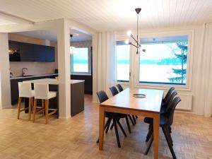 a dining room and kitchen with a table and chairs at Kotirinne 135 - järven rannalla in Jyväskylä