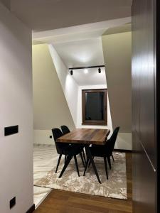 - une salle à manger avec une table et des chaises en bois dans l'établissement Apartman GLECER KOP, à Kopaonik