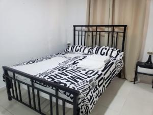 a bed with black and white sheets and pillows at Apartamento Familiar y tranquilo in Pantoja