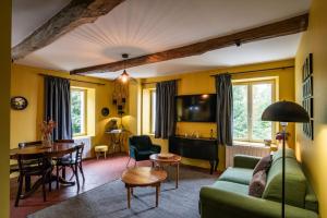 a living room with a couch and a table at Les appartements du Domaine de Maffliers 4 étoiles - Demeures de Campagne in Maffliers