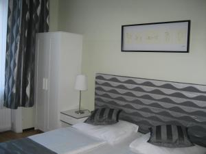 a bedroom with two beds and a picture on the wall at Pension Schottentor in Vienna