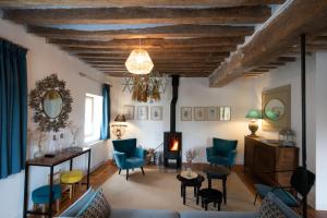 uma sala de estar com cadeiras azuis e uma lareira em Les appartements du Domaine de Maffliers 4 étoiles - Demeures de Campagne em Maffliers