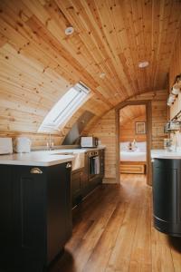 a kitchen with a wooden ceiling with a sink and a stove at Daffodil in Rhayader