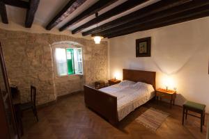 a bedroom with a bed and two tables and a window at Holiday Home Mihovilovic in Premantura