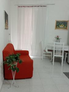 a living room with a red couch and a table at Appartamento Lorena in Trapani