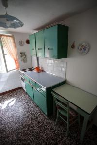 a kitchen with green cabinets and a table in it at Holiday Home Mihovilovic in Premantura +6 photos