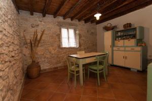 a kitchen with a table and chairs and a refrigerator at Holiday Home Mihovilovic in Premantura