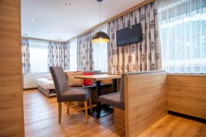 a room with a table and chairs and a tv at Marlis Apartments in Ischgl