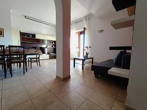 ein Wohnzimmer und eine Küche mit einem Tisch und einem Sofa in der Unterkunft Avellini - Delightful and Spacious Apartment with terrace - near Metro A Cornelia in Rom