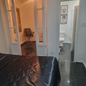 Habitación con cama, silla y aseo. en The best Copacabana Luxury Design 3 Bedroom room 3 bathroom 85 inch cinema tv top location, en Río de Janeiro