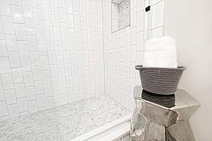 a bathroom with a shower with a basket of towels at The Kozy Urban Dallas Flat in Dallas
