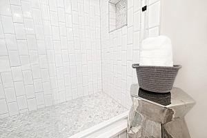 a bathroom with a shower with a basket of towels at FIFA Ready The Kozy Urban Dallas Flat in Dallas