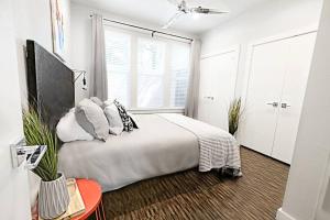 a bedroom with a bed with pillows and a window at The Kozy Urban Dallas Flat in Dallas