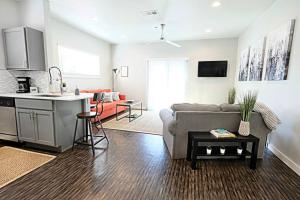 a living room with a couch and a kitchen at The Kozy Urban Dallas Flat in Dallas