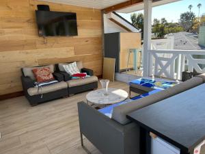 sala de estar con sofá y TV de pantalla plana en Bright modern new coastal home with inspiring details in Santa Monica, en Los Ángeles