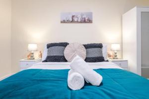um quarto com uma cama azul e branca com almofadas em Luxury Modern House In The Heart of Manchester em Manchester