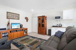 a living room with a couch and a kitchen at Laurelview Gympie in Gympie