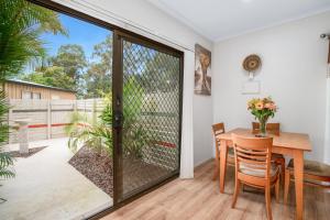 een eetkamer met een glazen deur naar een patio bij Laurelview Gympie in Gympie