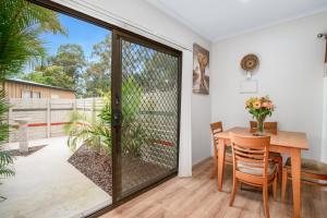 a dining room with a glass door leading to a patio at Laurelview Gympie in Gympie
