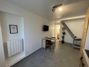Zimmer mit einem Schreibtisch und einer Treppe. in der Unterkunft Superbe T3 Duplex proche Paris & Disneyland in Ozoir-la-Ferrière