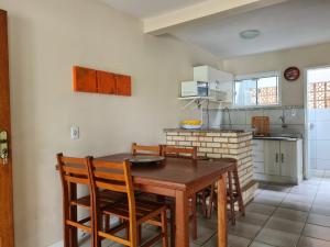 - une cuisine avec une table et des chaises en bois dans l'établissement RESIDENCIAL COM CASAS DE 3 DORM, à Garopaba