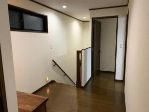 ein leeres Zimmer mit einer Tür und einer Treppe in der Unterkunft Azuma Taku - Vacation STAY 13741 in Kanie