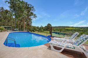 a swimming pool with two lounge chairs next to it at Laurelview Gympie in Gympie