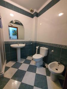 bagno con lavandino, servizi igienici e specchio di Piso tres dormitorios centro de Marchena. Sevilla a Marchena