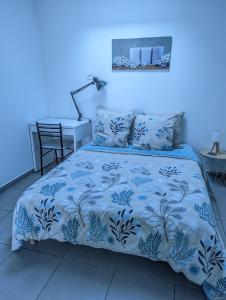 Vouneuil-sous-Biard的住宿－Bel Appartement T2 Climatisé avec piscine Poitiers-Futuroscope-CREPS de Poitiers，蓝色的卧室,配有一张蓝色墙壁的床