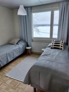 sypialnia z łóżkiem i dużym oknem w obiekcie Kotirinne 135 - järven rannalla w mieście Jyväskylä