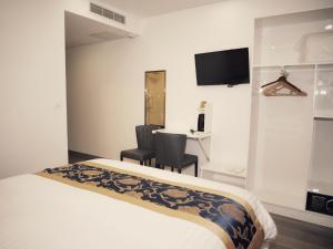 um quarto de hotel com uma cama, uma secretária e uma televisão em KYRIAD ROUEN SUD - Sotteville les Rouen em Rouen