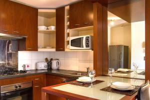 a kitchen with a counter with two glasses of wine at San Ignacio Suite Apartments in Santiago
