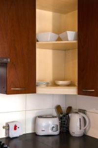 a kitchen with white toasters and bowls on shelves at San Ignacio Suite Apartments in Santiago