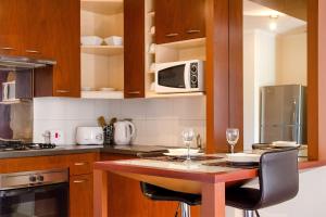 cocina con mesa con sillas y microondas en San Ignacio Suite Apartments, en Santiago