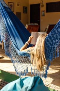 a woman laying in a hammock reading a book at Pousada La Vie Jeri in Jericoacoara +132 photos