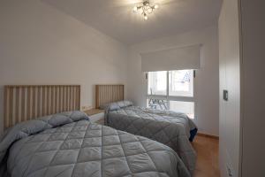 1 dormitorio con 2 camas y ventana en Holiday Beach Brissa Mar, en Gran Alacant