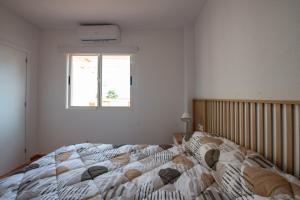 1 dormitorio con 1 cama grande y ventana en Holiday Beach Brissa Mar, en Gran Alacant