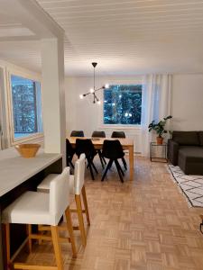 a dining room and living room with a table and chairs at Kotirinne 135 - järven rannalla in Jyväskylä