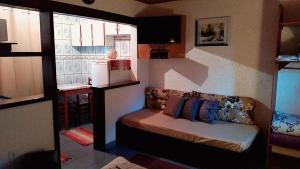 ein Wohnzimmer mit einem Sofa und einem Fenster in der Unterkunft Chales Encanto Suíço in Monte Verde