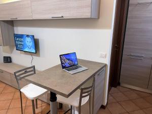 um computador portátil sentado numa mesa numa cozinha em Appartamento Seregno Galileo - Centro - ABI em Seregno
