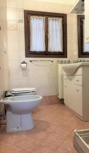 uma casa de banho com um WC branco e um lavatório. em Appartamento Seregno Galileo - Centro - ABI em Seregno