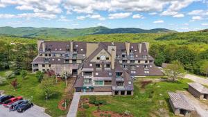 an aerial view of a large building with cars parked in a parking lot at Mountain Green Resort by Killington VR - 2 Bedrooms in Killington