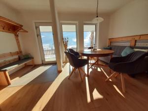 a living room with a table and chairs and windows at Ferienwohnung Sunnseitn in Haus im Ennstal