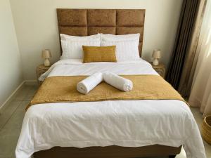 una camera da letto con un letto grande con due asciugamani sopra di Zimbali Lakes Boulevard Royal Suite 116 a Ballito Altre 16 foto