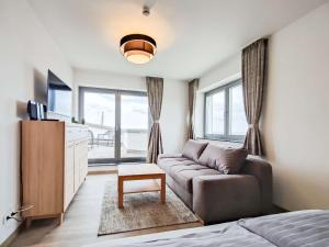 ein Wohnzimmer mit einem Sofa und einem TV in der Unterkunft Cornelius-04 in Norderney