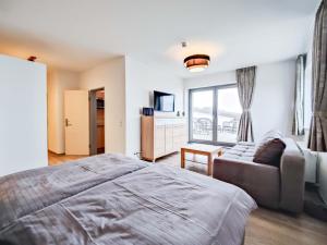 ein Schlafzimmer mit einem großen Bett und einem Sofa in der Unterkunft Cornelius-04 in Norderney