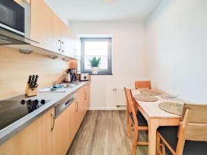 eine Küche mit einem Tisch und einem Esszimmer in der Unterkunft Cornelius-04 in Norderney