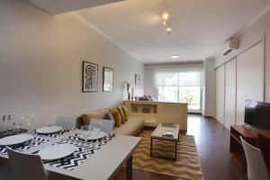 uma sala de estar com uma mesa e um sofá em Minimalist design apartment with amazing view em Buenos Aires