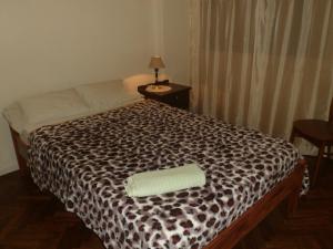 a bedroom with a bed with a cheetah print sheets at Edificio Columbia in Asunción