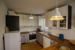 a kitchen with white cabinets and a white refrigerator at House Pucnk-beautiful countryside in Železniki
